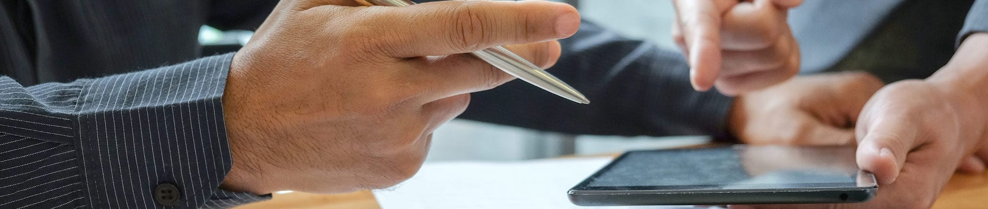 Business management team is summarizing the work in the office.Businessmen use tablet and laptop. Data graphs placed on the desk.